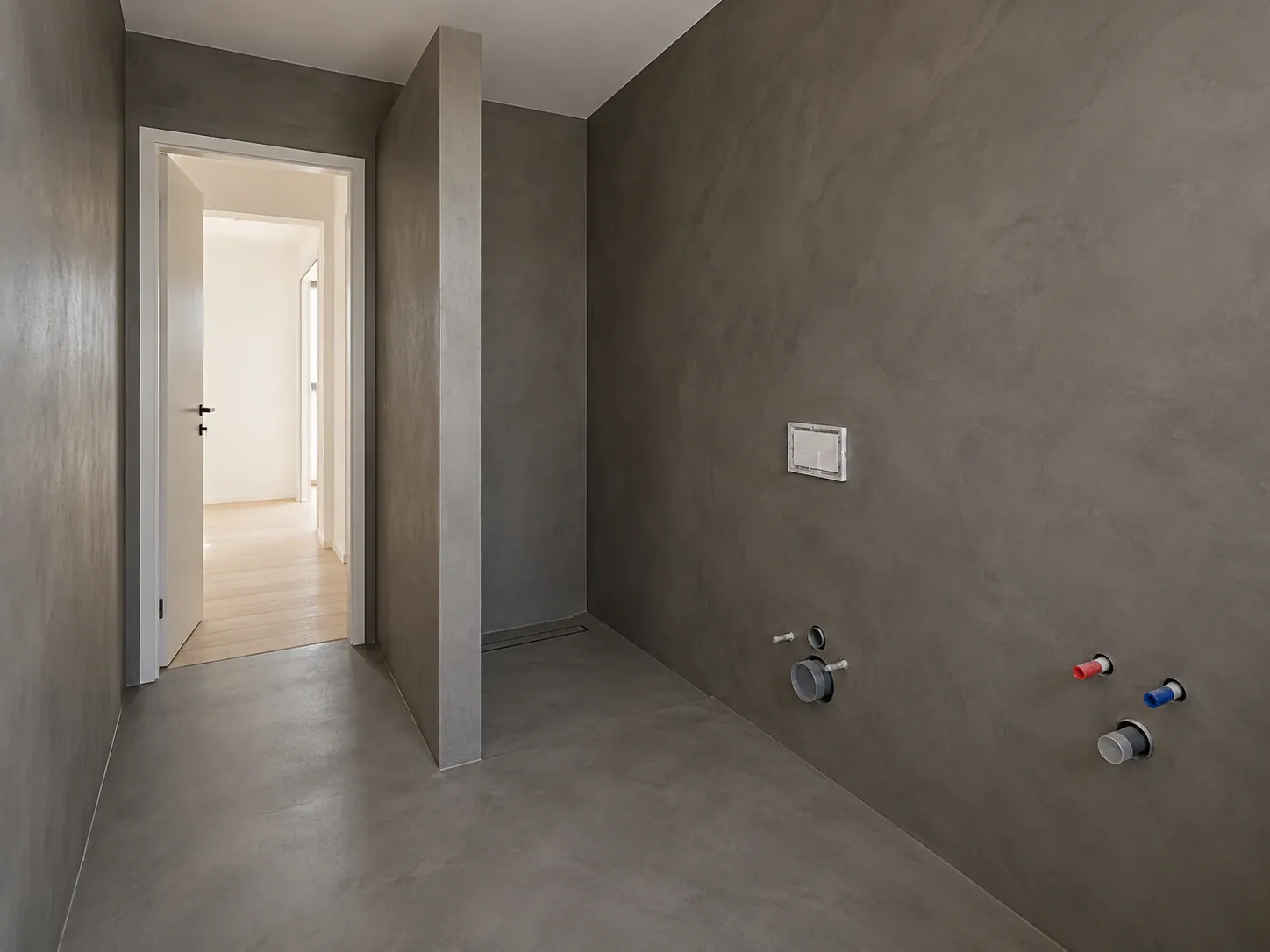 Graphite microcement bathroom with a walk-in shower, walls and floor as one surface