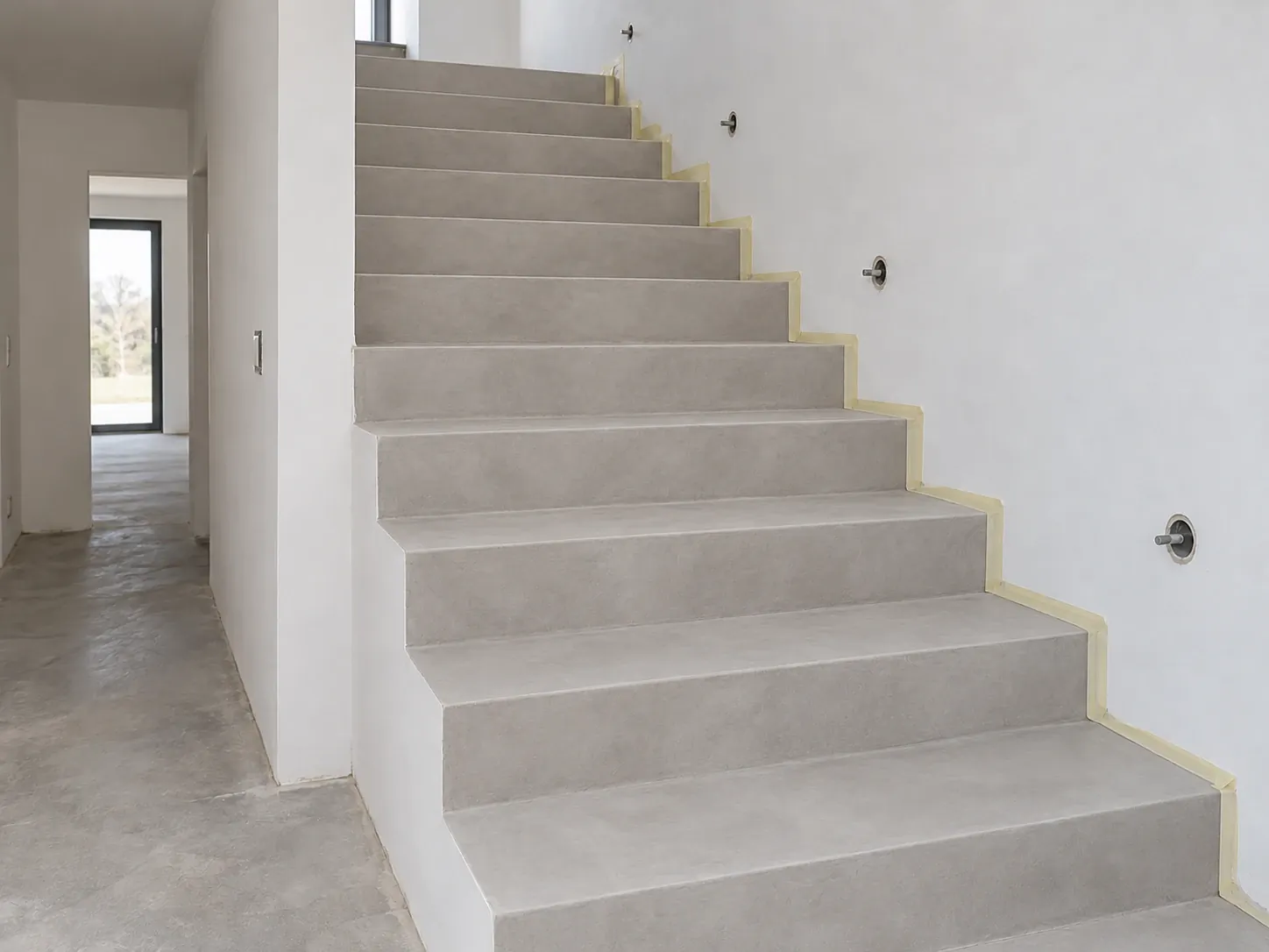 Grey microcement staircase in a bright family house, treads and risers in one colour