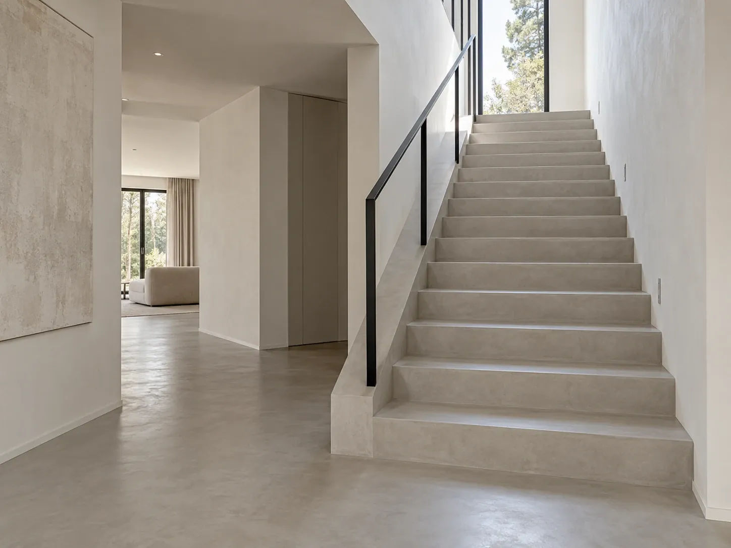 Microcement staircase in the colour of the floor, black steel handrail, bright house with a tall window