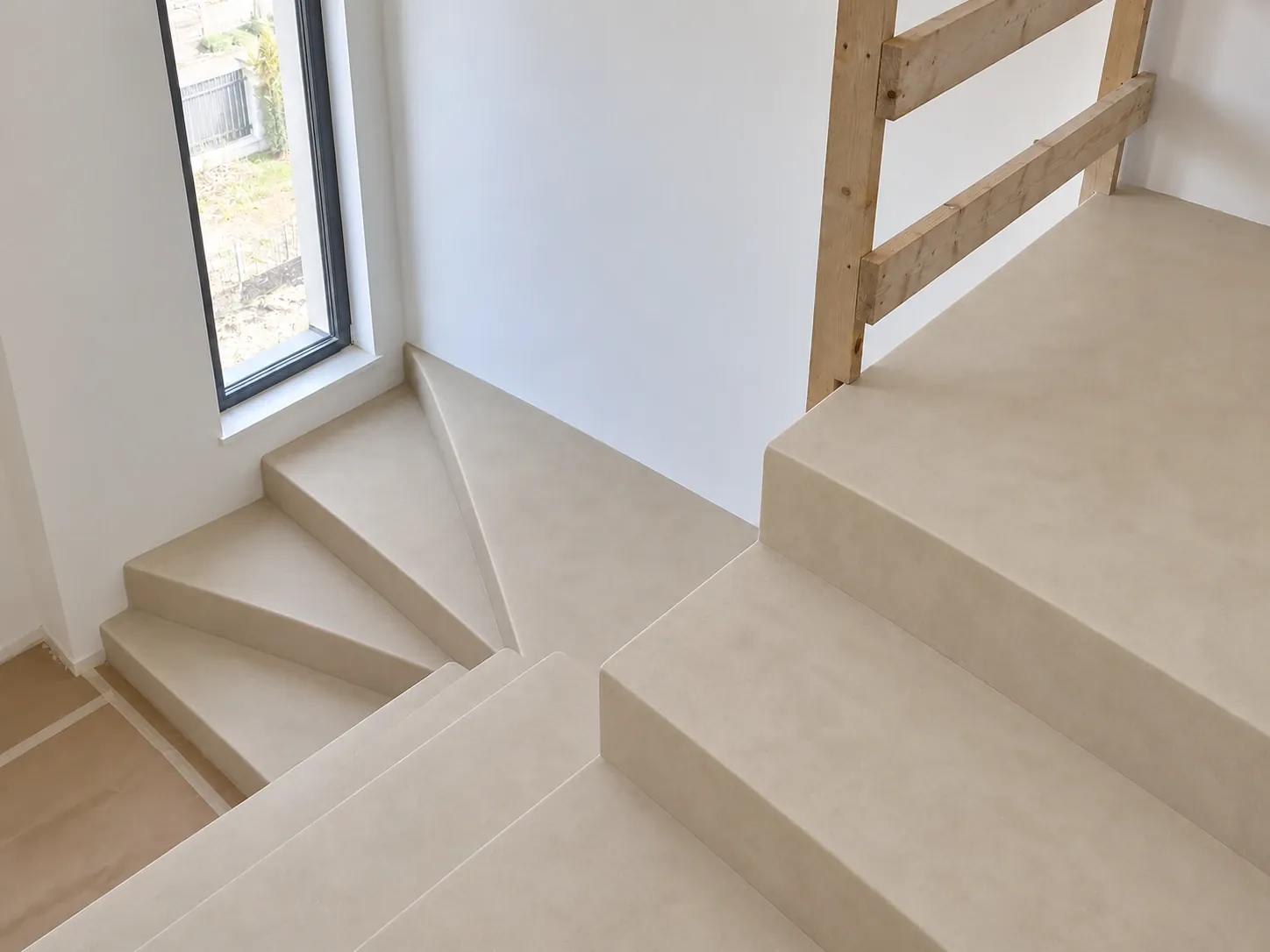 Beige microcement winder staircase seen from above, steps and landing